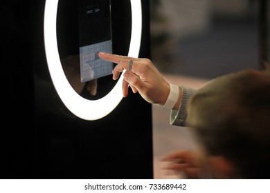 Woman's Hand Dialing Numbers On A Glowing Digital Touch Screen Of A Terminal In The Shopping Mall. Self Service