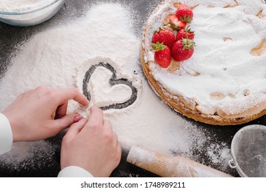 Woman's hand drawing a heart on a table covered with flour. Baking with love. Food photo