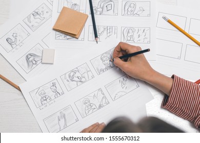 Woman's hand draws a storyboard for a film or cartoon. - Shutterstock ID 1555670312