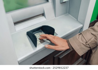 Woman's hand entering pin code on atm keypad for secure transaction, ensuring financial security and convenience for customers