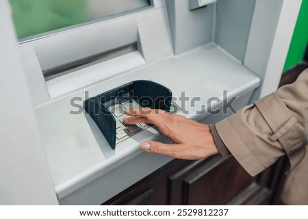Woman's hand entering pin code on atm keypad for secure transaction, ensuring financial security and convenience for customers