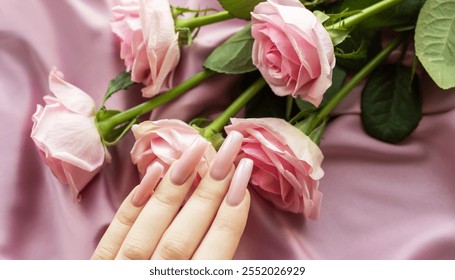 Woman's hand with fashionable pink manicure and engagement ring lying near bouquet of pink roses on silk fabric - Powered by Shutterstock