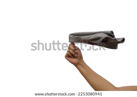 Woman's hand with finger swinging used men's underwear on white background. The picking sensation looks disgusting when handling used clothing.