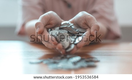 Woman's hand full of coins, Business people saving money for future investment, saving money, Silver baht coins,Finance and investment, including taxes, Spending money like maturity concept.