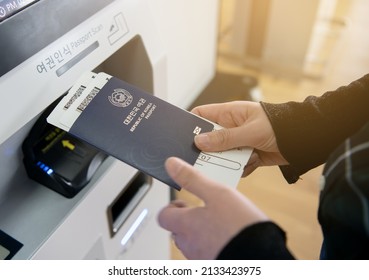 Woman's hand getting a ticket using self check-in kiosk at the airport