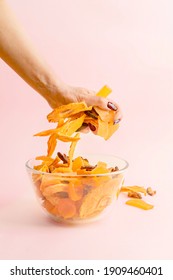 Woman's Hand Grabbing Handful Of Dried Fruit From A Bowl With Assorted Vegan Jerky.