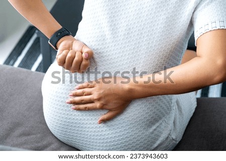 woman's hand he is caught at the waist and her back is painful at the back in the room. health concept