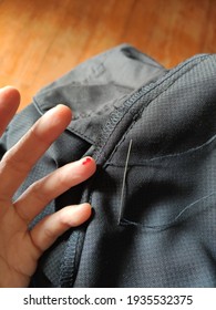 Woman's Hand With Her Blood On Ring Finger With Sewing Needle, Thread And Black Slack Pants. Accident At Housework Concept.