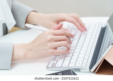 A woman's hand hitting a computer keyboard