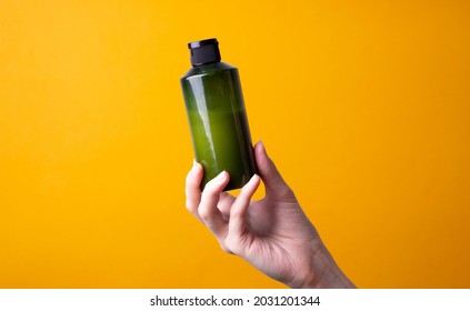 Woman's Hand Holding A Bottle Of Shampoo