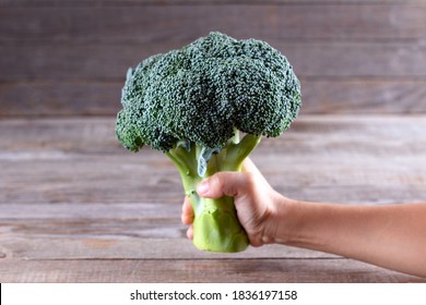 Woman's Hand Holding Brocoli On White Background