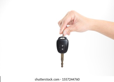 A woman's hand holding a car key on an isolated background