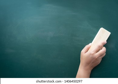 Woman's hand holding chalk board eraser and deleting the board, teacher and school supplies