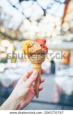Woman's hand holding cone with italian ice cream. Gelato.