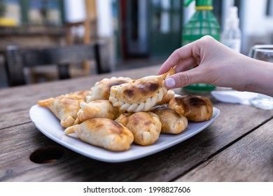 Woman's Hand Holding An Empanada - Typical Argentine Food