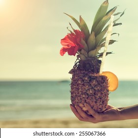 Woman's hand holding exotic pineapple cocktail. - Powered by Shutterstock