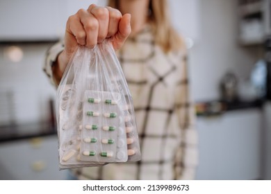 Woman's hand holding expired pills ready to recycle. - Shutterstock ID 2139989673