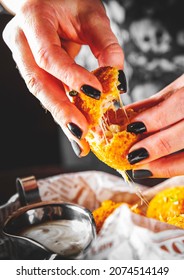 Woman's Hand Holding Fried Mozzarella Cheese Ball