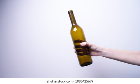 A Woman's Hand Holding A Glass Bottle