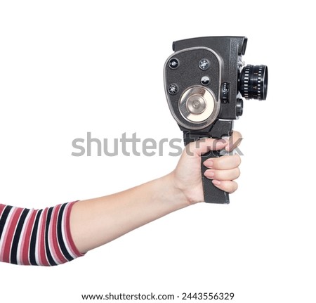 Woman's hand holding an old 8 mm movie camera, isolated on white background. File contains a path to isolation.