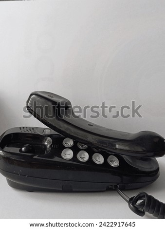 A woman's hand is holding an oldstyle phone on the white background 