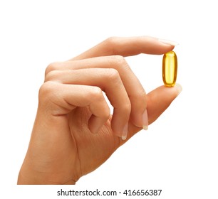 Woman's Hand Holding Omega 3 Capsule Isolated On White Background. Close Up. High Resolution Product.