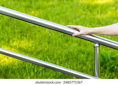 woman's hand holding onto the metal staircase railing. metal stair handrail. woman climbing stairs.  - Powered by Shutterstock