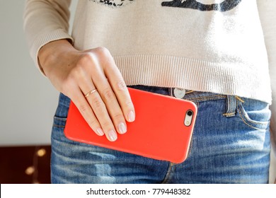 Woman's Hand Holding The Phone In The Red Case Close Up