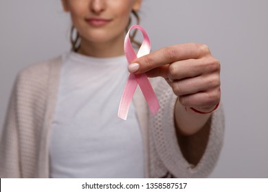 Woman's Hand Holding Pink Ribbon Isolated.