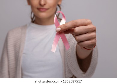 Woman's Hand Holding Pink Ribbon Isolated.