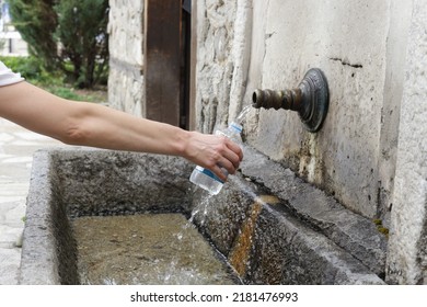 Woman`s Hand Holding Plastic Water Bottle And Refill With Fresh Spring Water	