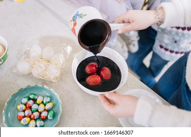 Woman's Hand Holding A Pot Pouring Paint Over Eggs