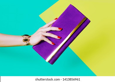 Woman's Hand Holding Purple Purse