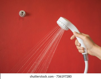 Woman's Hand Is Holding The Shower In The Bathroom , Which Is Sprayed With Water.