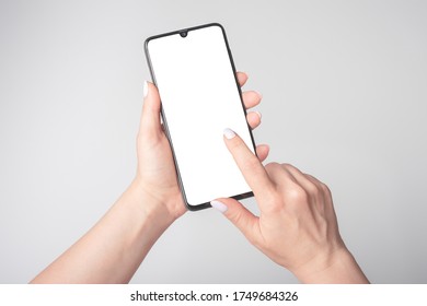 Woman's Hand Holding Smartphone With Blank Screen, Mockup Phone, Gray Background