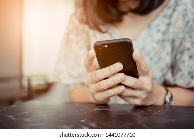 The woman's hand is holding a smartphone.
She is using the smartphone. - Shutterstock ID 1441077710
