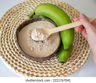 Woman's Hand Holding A Spoon With Green Banana Flour.