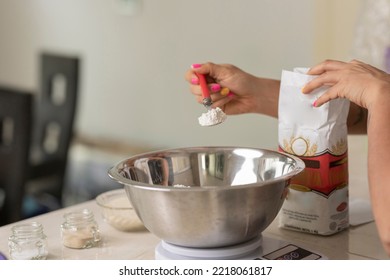 Woman's Hand Holding A Spoon, To Weigh The Flour And Make Bread