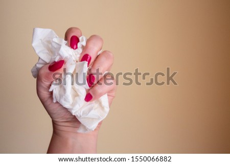 Woman's hand holding white tissue