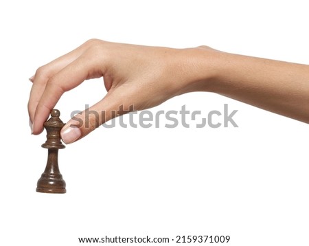 A woman's hand holds a chess piece on a white background, isolat