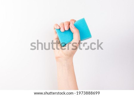 woman's hand holds a cleaning sponge isolated on  white background
