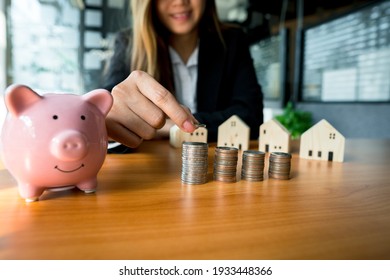 A Woman's Hand Holds A Coin To Manage Money And Plan Your Savings To Buy The Best Home For Your Family, Ideas For Savings, Growth, Economy, Business And Investing.