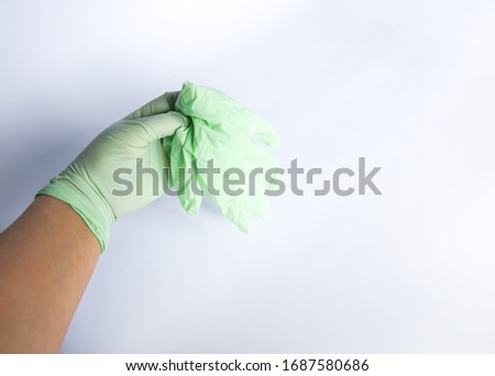 Woman's hand holds the rubber glove.