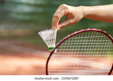 A Woman's Hand Holds A Shuttlecock For Badminton, Is Going To Hit It With A Racket On A Sports Court, Fitness Outdoor