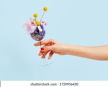 Woman's hand holds wine glass filled with flowers - Powered by Shutterstock
