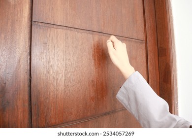 woman's hand knocking the door - Powered by Shutterstock