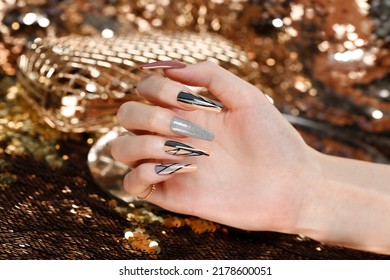 Woman's hand with long nails and green manicure with bottles of nail polish - Shutterstock ID 2178600051
