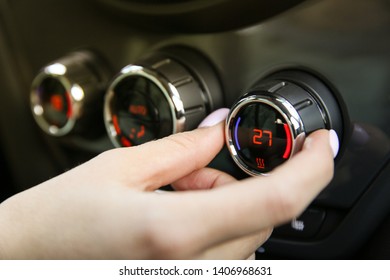 the woman's hand makes the temperature in the car at 27 degrees. adjust the climate control of the car - Shutterstock ID 1406968631