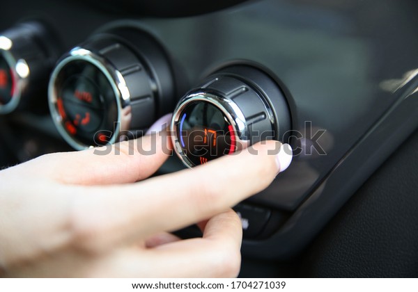 the woman\'s hand makes the\
temperature in the car at 17 degrees. adjust the climate control of\
the car