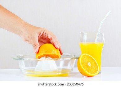 Woman's Hand Making Orange Juice Using A Juicer